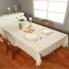 Lace table runner on a dining table in natural light, featured in Clearance Table Linen Sale.