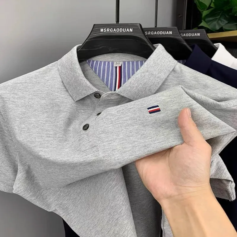 A close-up view of a gray men's breathable polo shirt being held, showcasing its texture and design details.