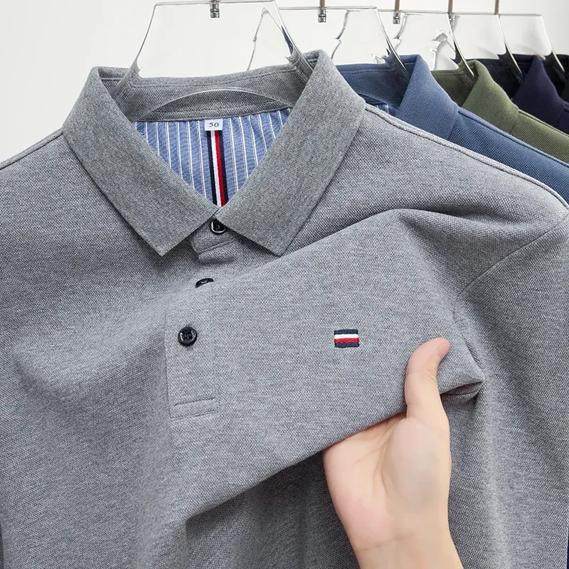 A close-up view of a gray men's embroidered polo shirt, highlighting its classic design and subtle branding.