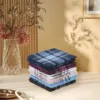 Stack of men's pocket handkerchiefs set placed on a table, surrounded by decorative elements.