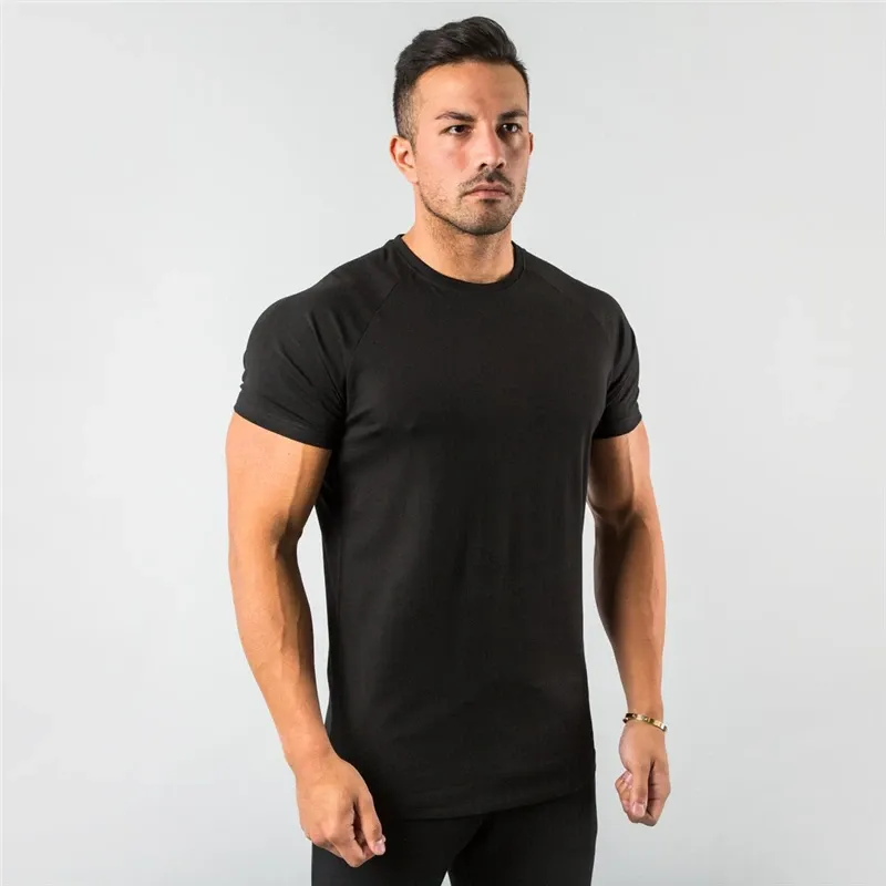 Man displaying a sleek black, short-sleeve t-shirt with a timeless design.