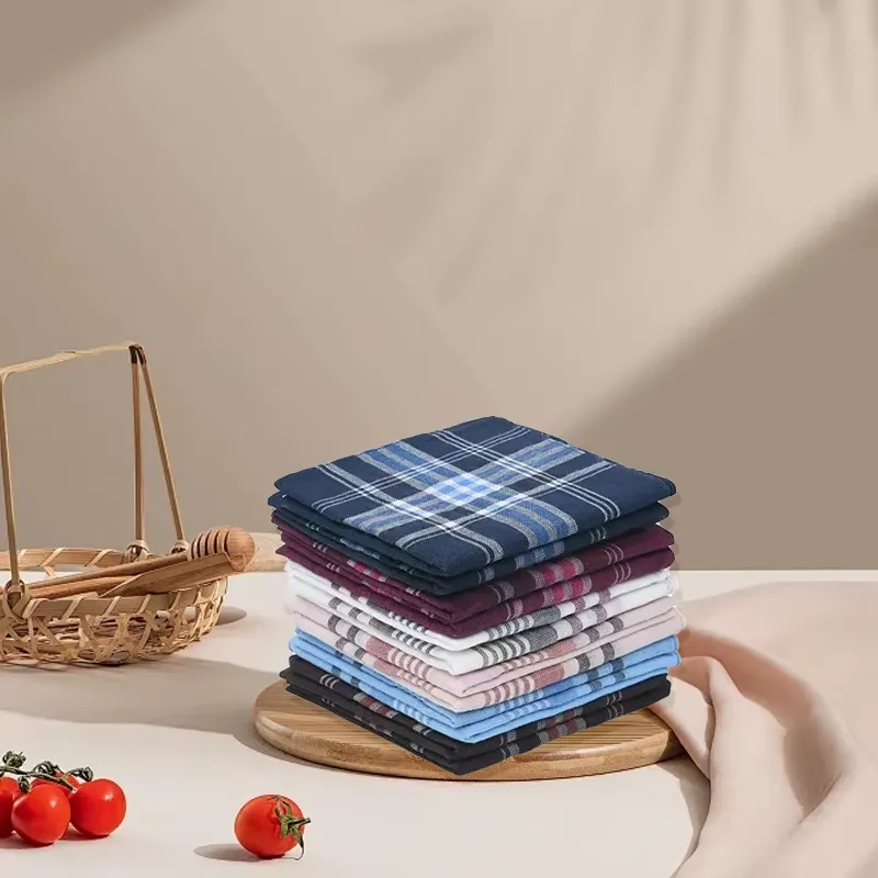 Stack of Classic Stripe Plaid Handkerchiefs displayed on a wooden stand with a rustic basket and fresh tomatoes in the background.