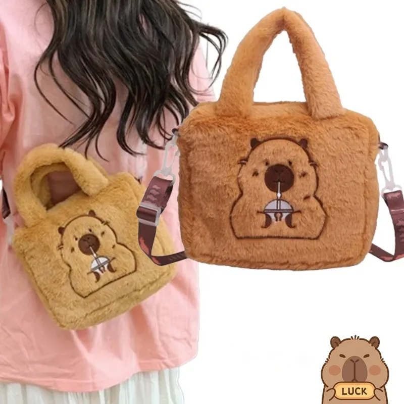 A person holding two cute capybara plush bags, one in a smaller size and the other in a larger size.