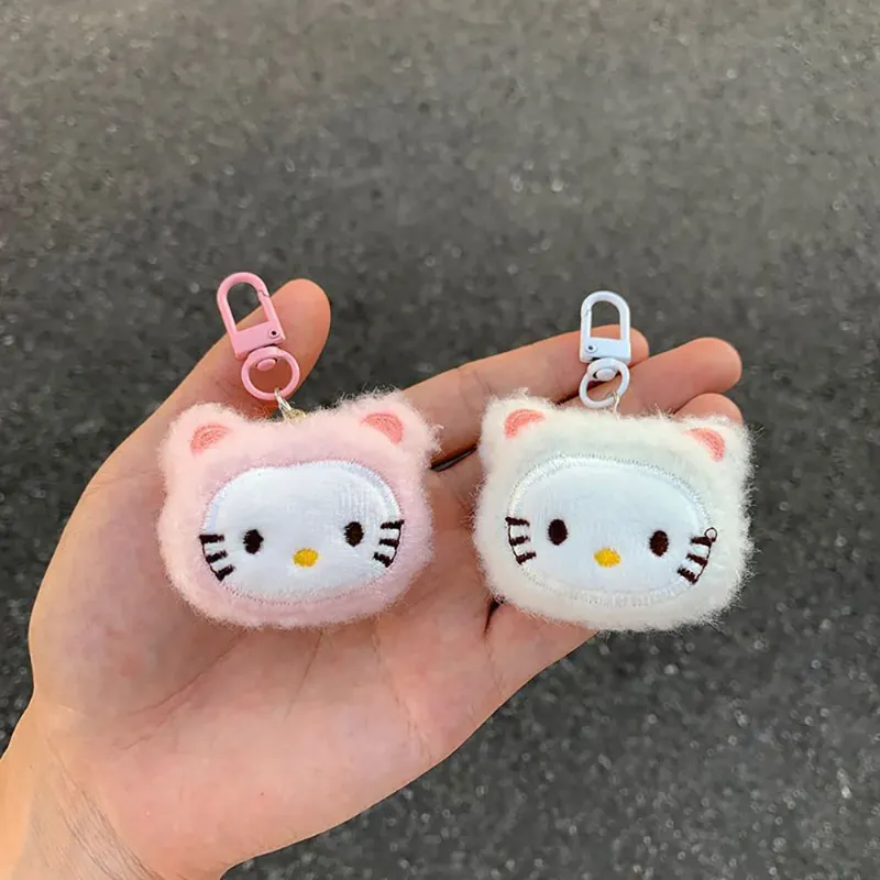 Two adorable Hello Kitty Plush Keychains held in hand, showcasing their soft and fluffy designs in pink and white.