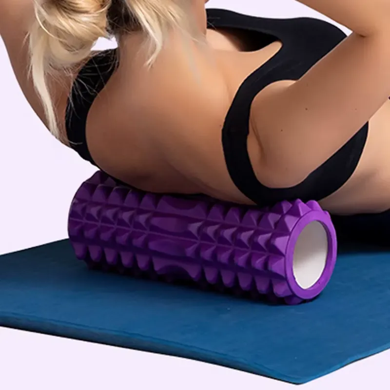 User lying on a hollow foam roller for back and core support during an exercise routine.