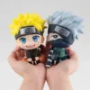 Two Naruto Q Version Figures held in hands, featuring Naruto and Kakashi in their iconic outfits.
