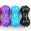 Set of colorful spiky massage balls in purple, blue, black, and pink, featuring textured surfaces for deep tissue relief.