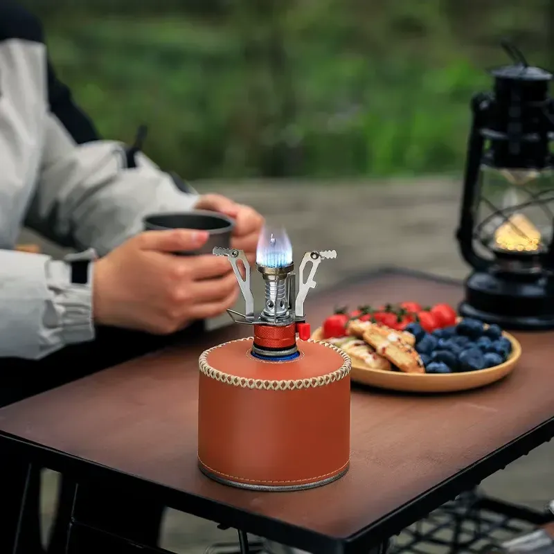 Ultralight portable camping stove with a bright flame, perfect for outdoor cooking.
