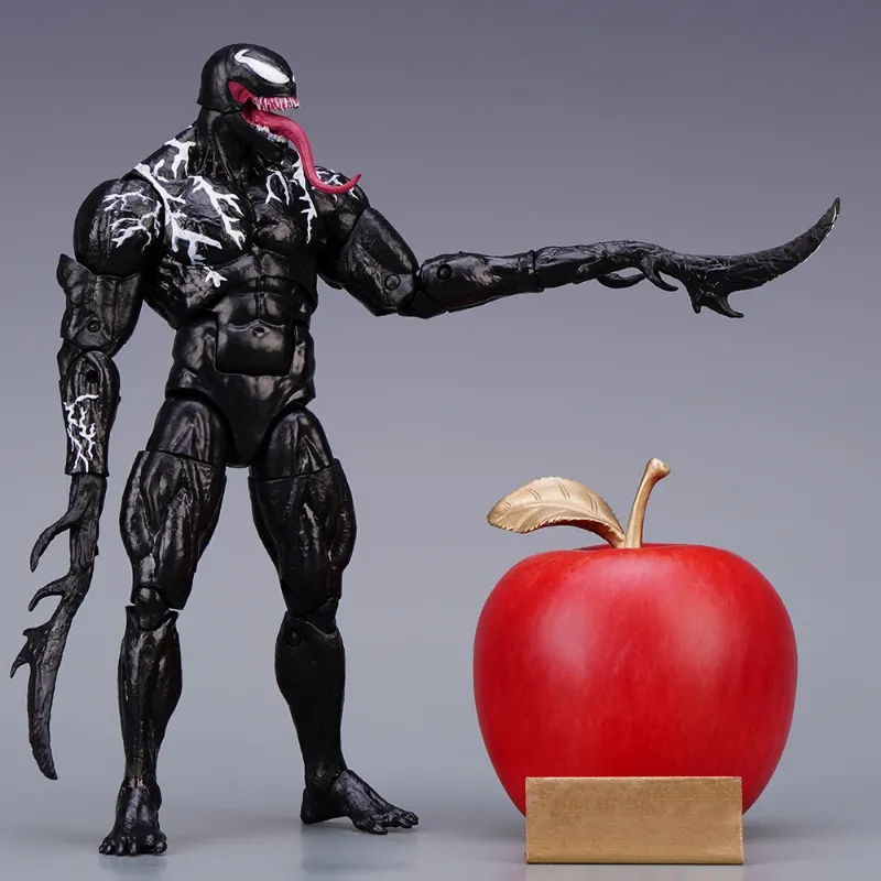 A 20cm tall Venom Action Figure Hasbro standing next to a red apple for scale comparison. The figure is equipped with long, sharp symbiote tendril hands.