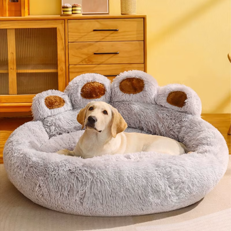 A dog smiling at the camera while resting in a large, fluffy bed.