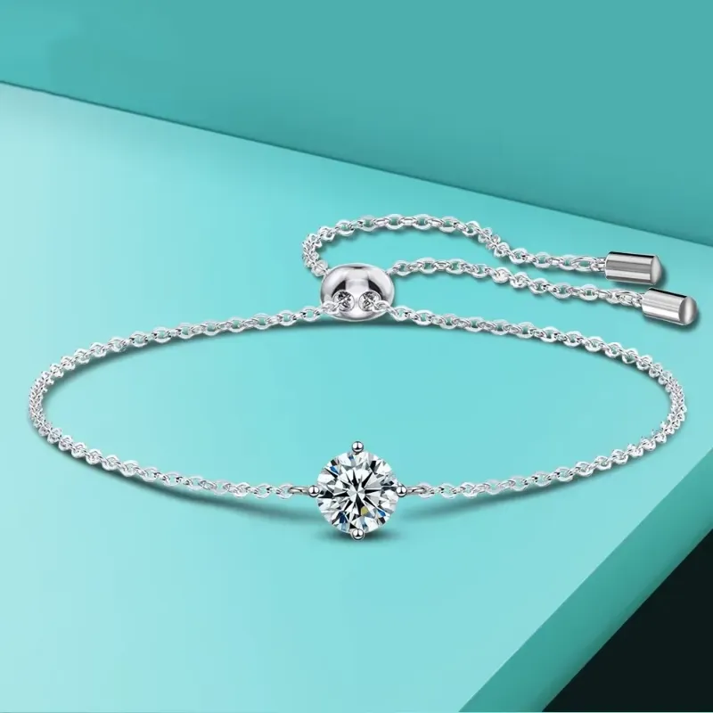 A stunning Certified Moissanite Tennis Bracelet with a delicate chain and a brilliant moissanite stone, displayed against a vibrant teal background.