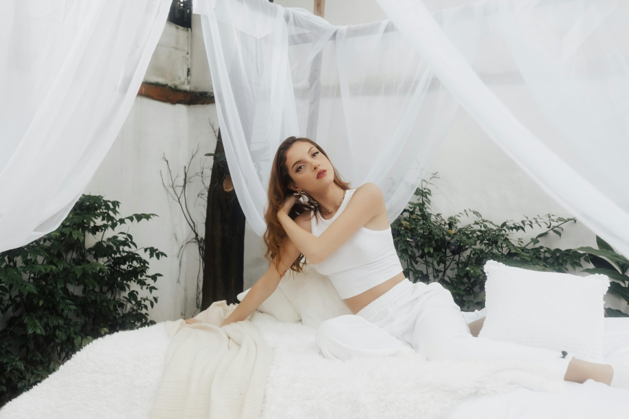 a hot lady on a white bed 