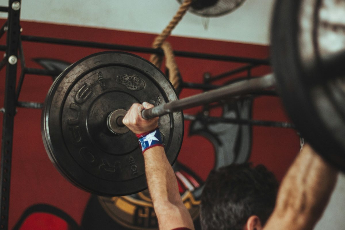 Sport: A man overhead pressing weights