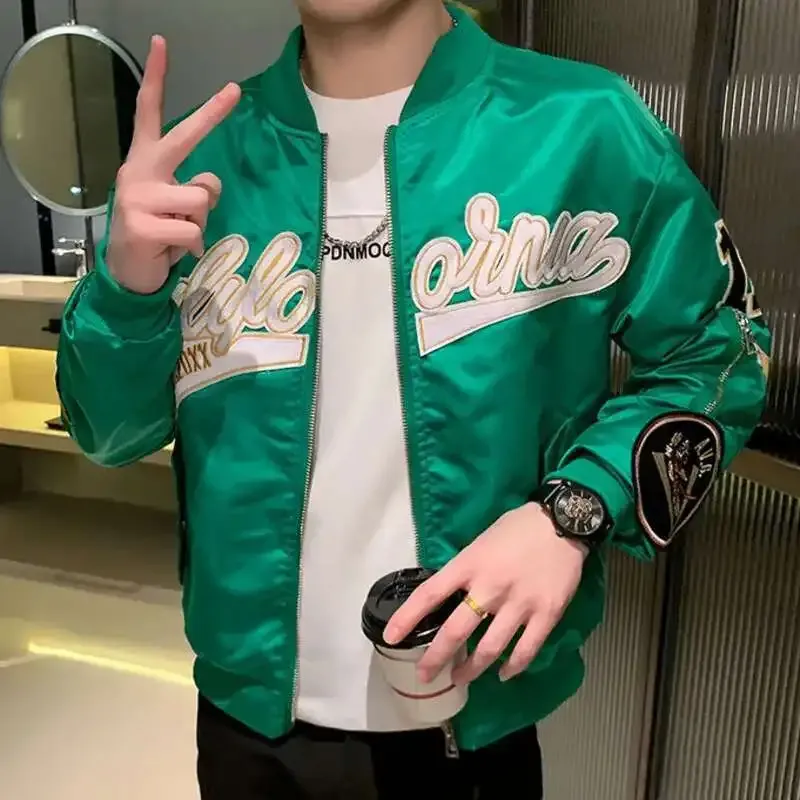 A person wearing a green Hip Hop Baseball Jacket, striking a pose with a peace sign and holding a coffee cup.