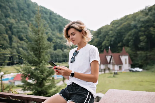 nice girl lean back to the edge of the stairs and working with her smartphone