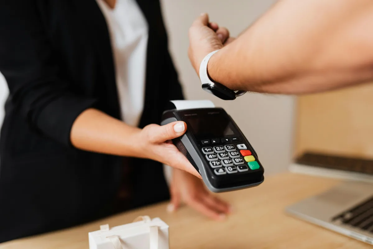 a man is paying the bill with his smartwatch