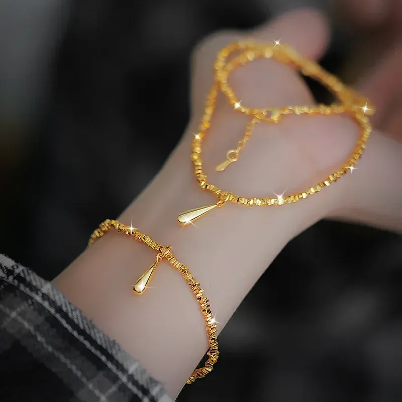 24K real gold bracelet with shattered gold droplets on woman's wrist