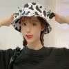 Man wearing cow print bucket hat while fishing