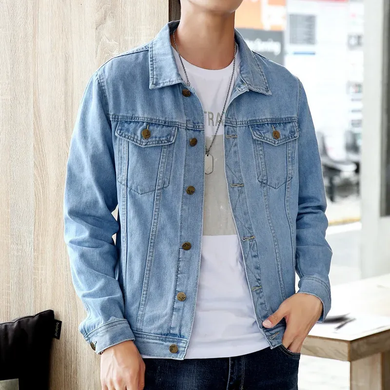 Man in a light blue mens denim jacket casual, accessorized with a necklace and layered over a graphic tee.
