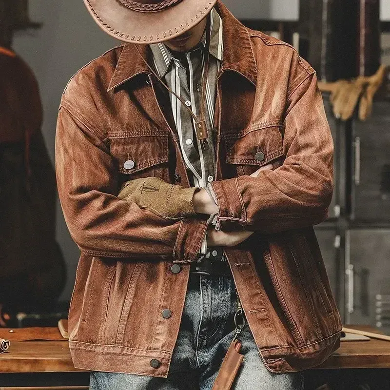 Man wearing a vintage denim jacket men in brown, accessorized with a cowboy hat and gloves, standing confidently.