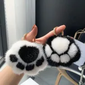 Fluffy Cat Paw Keychains held in hand, showcasing their soft and adorable black-and-white design.